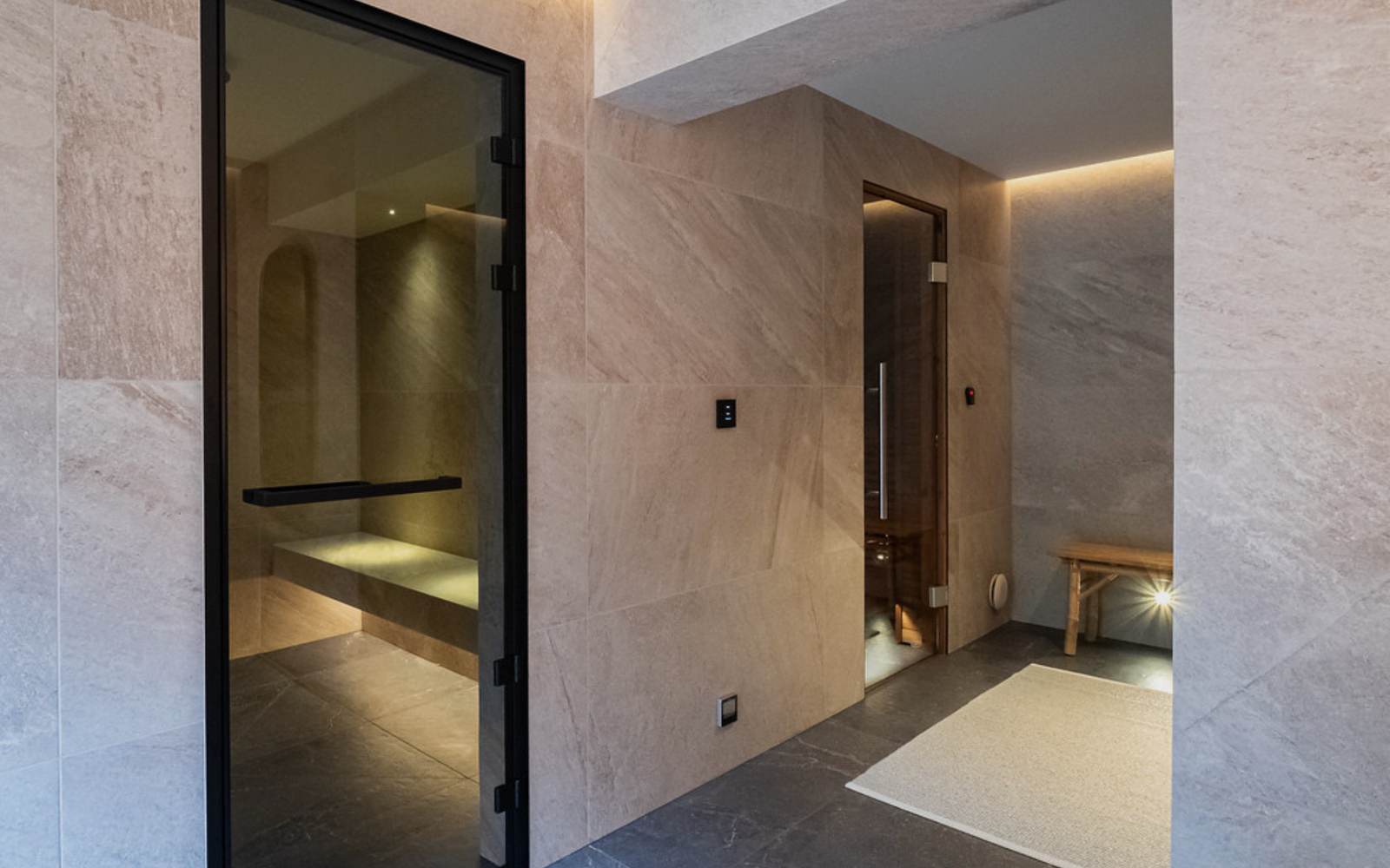 Modern interior with marble walls and a glass door leading to another room.