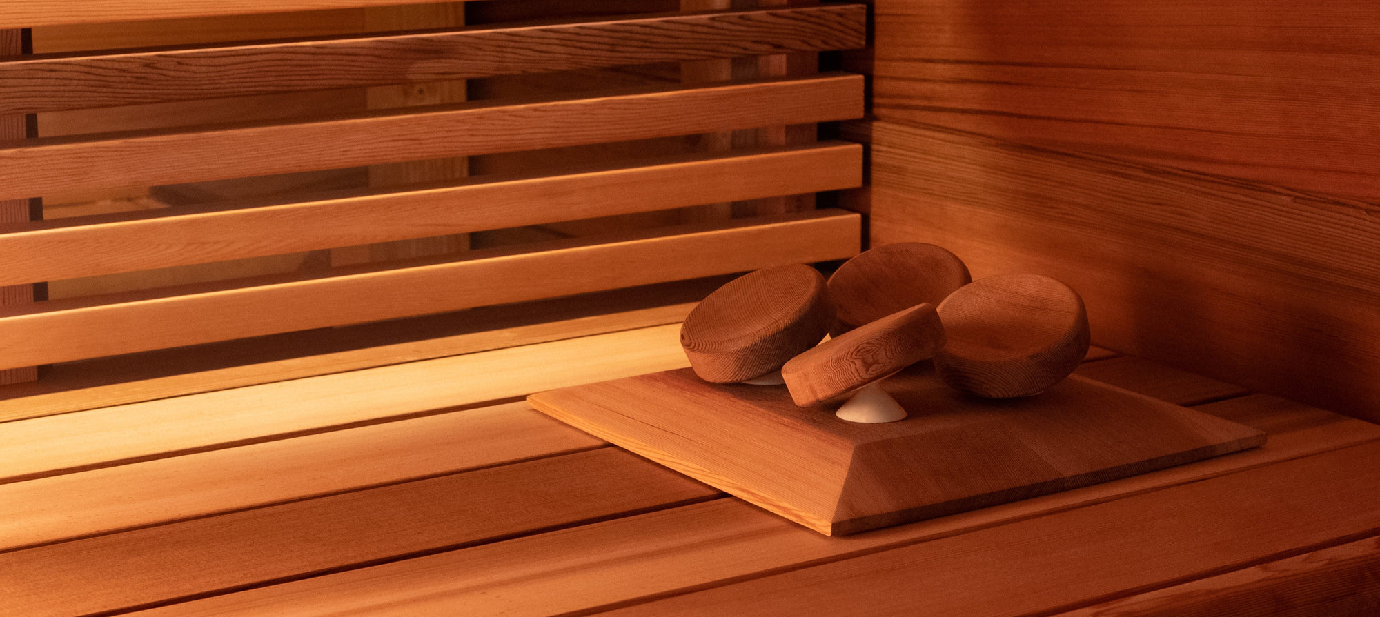 Western Red Cedar Sauna Installation with wide cedar cladding and sauna bench with slatted skirting. Pivoting Halu sauna headrest in western red cedar is also visible.