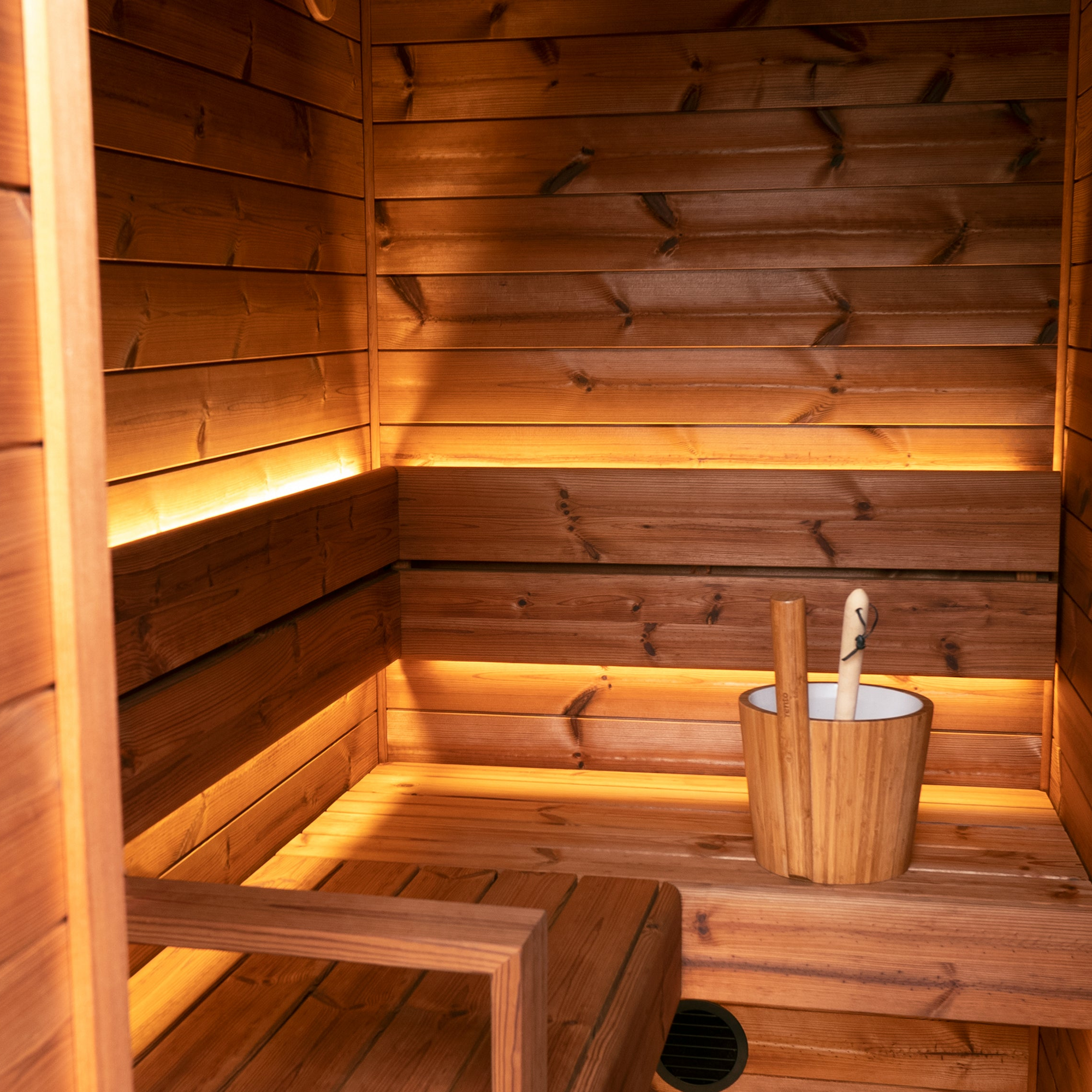 Wooden sauna interior with a bucket.