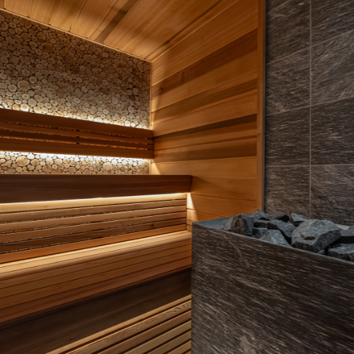 Wooden sauna interior with stone wall and rock basin