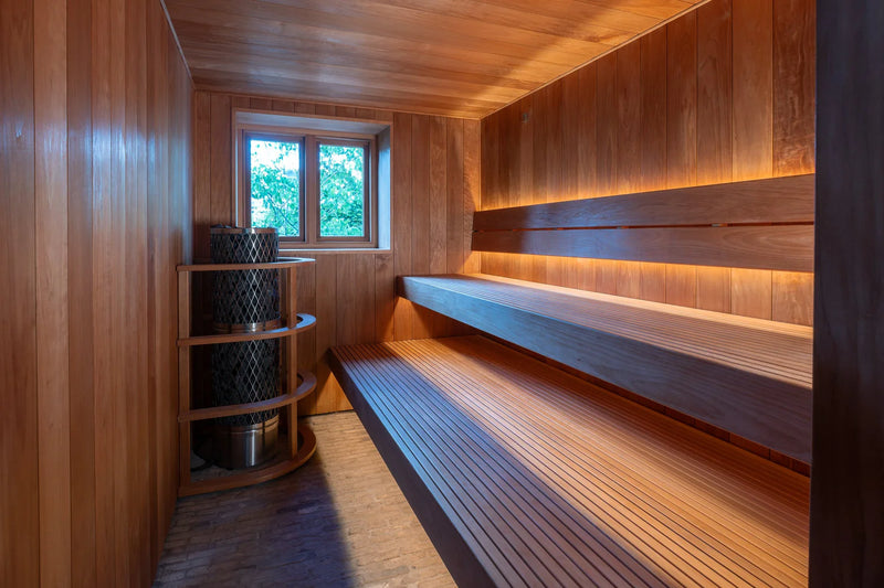Wooden sauna with a bench and shelves.