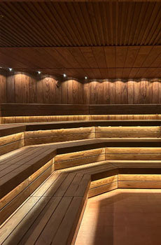 Wooden sauna interior with benches and warm lighting