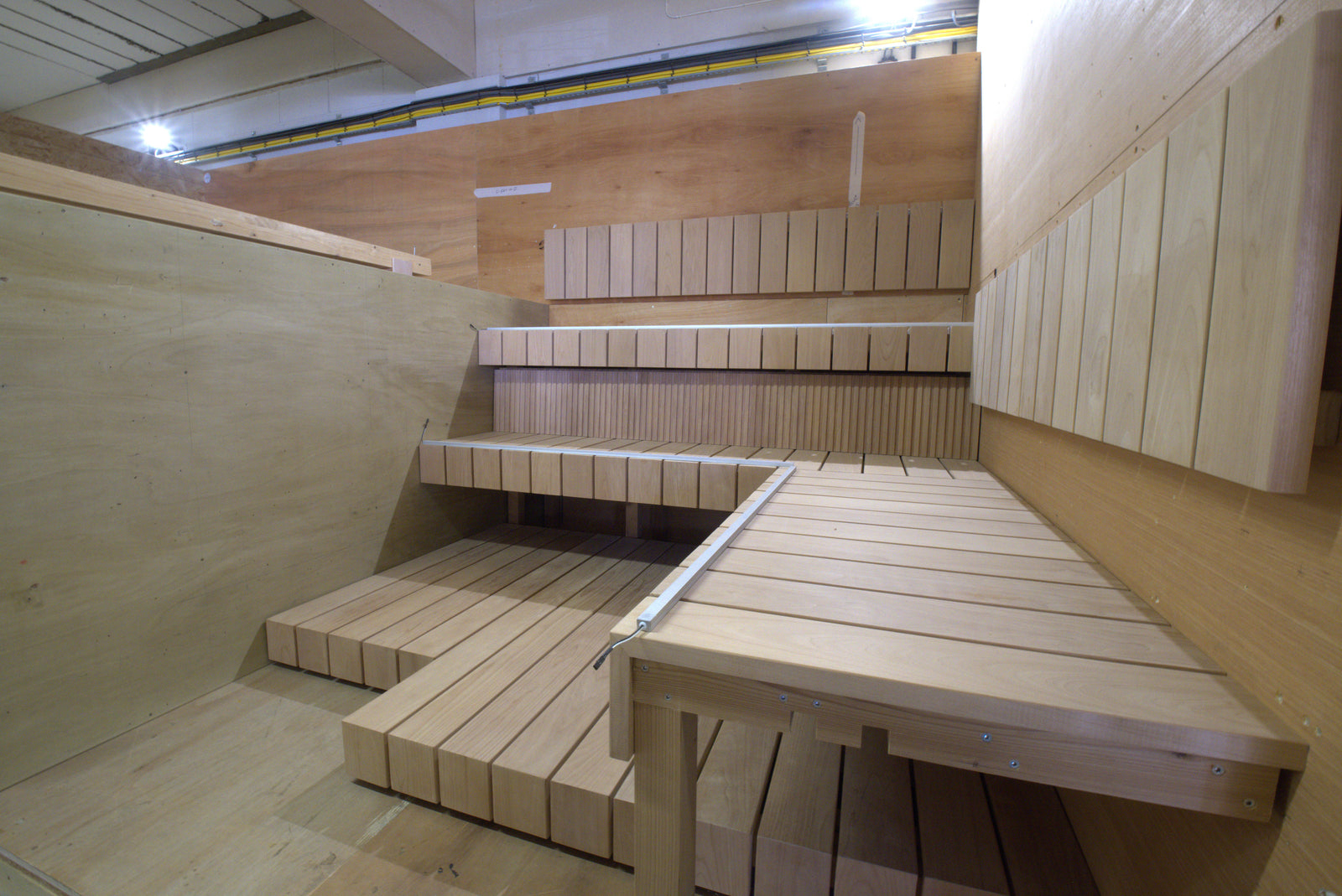 Wooden sauna interior with benches and a table.