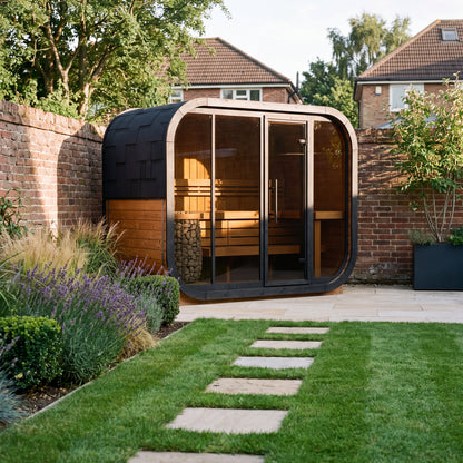 Ralva Large rounded outdoor sauna in a walled brick garden, warm lit interior seen through the glazed front