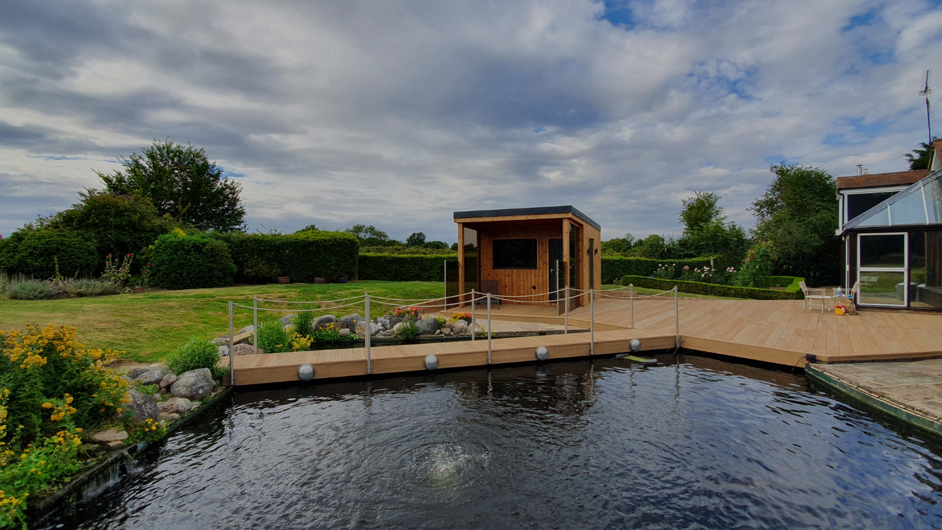 Wooden cabin by a pond with a cloudy sky