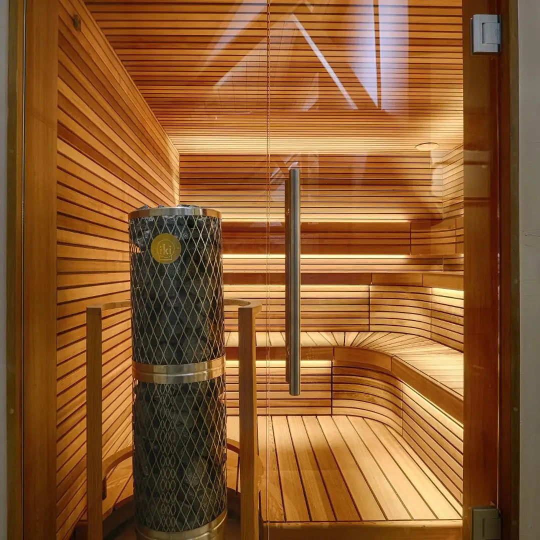Sauna with warm lighting and a stone lined heater