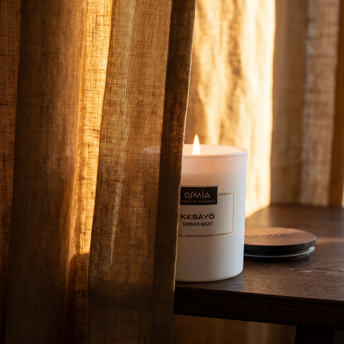 Summer Night Scented Candle by Osmia - lit behind linen curtain
