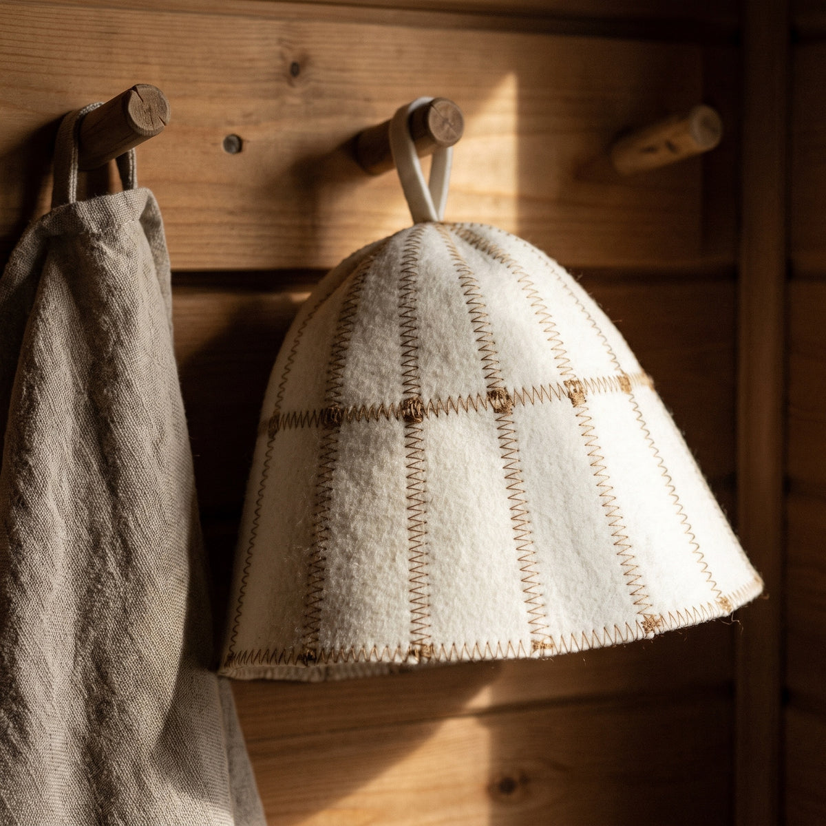 Sauna Hat Brown/White (Wool Felt) - hanging on a sauna peg