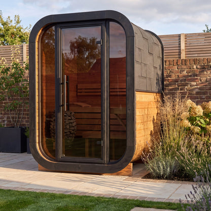 Ralva Small outdoor sauna set on a paved base in a walled garden
