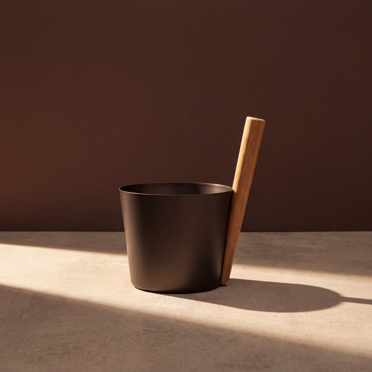 Rento 5l Anodised Aluminium Sauna Pail in Brown/Black - lifestyle in sunlight